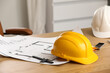 © Pixel-Shot - Hardhat with house plan on desk in office