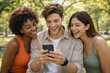 © thodonal - Friends enjoying a moment together while looking at a smartphone