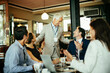 © Marko Geber - Business team applauding colleague at cafe meeting