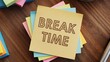 © Md - Stack of colorful sticky notes with 'BREAK TIME' on top on wooden desk