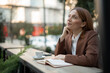 © Jelena - Woman dreaming on cafe terrace thinking about future