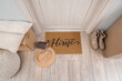 © Pixel-Shot - Doormat with hat and house model in hallway on moving day, top view