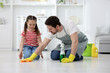 © New Africa - Spring cleaning. Father and daughter tidying up floor at home