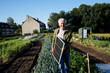 © Westend61 - Man holding solar panel in a sustainable vegetable garden