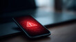 © Denis Yevtekhov - Smartphone screen showing a warning triangle error notification with a dark hacker-style interface glowing on a desk, defocused dark background, cybersecurity warning, hacker attac