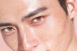© Naphatson - A close-up portrait of a young man with striking features, showcasing smooth skin, freckles, and captivating brown eyes against a soft pastel background.