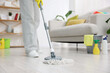 © New Africa - Spring cleaning. Woman tidying up floor with mop at home, closeup
