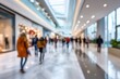 © neirfy - Blurred shoppers stroll a bright mall corridor with reflective floors and storefronts, evoking anonymous urban movement under artificial light.