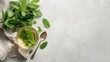© spyrakot - Top Down Flat Lay of Mint Leaves, Herbal Tea Cup, Linen Napkin, and Glass Spoon