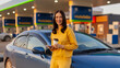 © Home-stock - Happy traveler woman enjoying quick coffee break beside her car at modern gas station, smiling at camera, panorama shot