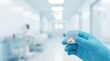 © Dmitriy K. - Gloved hand holding plastic cup with pills in blurred hospital hallway