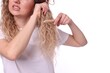 © New Africa - Woman trying to brush her tangled hair on white background, closeup