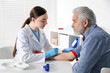 © New Africa - Doctor drawing senior man's blood sample in clinic
