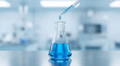 © ShahabudinKhan - Precise blue liquid drop from a pipette into an Erlenmeyer flask in a sterile bright modern laboratory environment for science