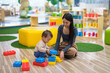 © leungchopan - Little baby building block tower with mum at playhouse