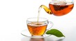 © SHAHELA - Tea being poured into a glass cup on a saucer with a leaf