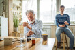 © Miljan Živković - Elderly man experiencing severe pain while grandson ignores him