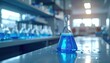 © NurAtikah - Glass beaker with blue liquid and bubbles on a laboratory countertop showcasing scientific research