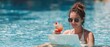 © Anatoll Paveel - Girl holding cocktail and using laptop in swimming pool