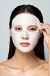 © Lubos Chlubny - Asian woman applying hydrating sheet mask for skin care