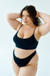© Bliss - Curly young plus size woman embraces body positivity in a studio setting