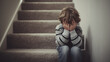 © Naufal - Young boy sitting alone on carpeted stairs, covering face with hands, crying in sadness, expressing loneliness, fear, and emotional distress.