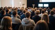 © Techwave Visuals - Large professional audience sitting and listening to a keynote presentation in a conference hall, business seminar and educational summit concept.