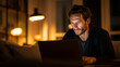 © Tahsin - A focused man works on his laptop in a dimly lit room.