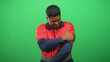 © Krakenimages.com - Man worker in red uniform clutching left arm with grimace in studio against green screen; workplace pain.