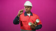 © Krakenimages.com - Man construction worker in hard hat holding rolled blueprints and pointing finger in studio; determination focus professionalism integrity.