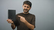 © Krakenimages.com - Young hispanic man with beard holding black book points finger to book in studio; curiosity learning.