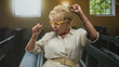 © Krakenimages.com - Woman raises hand while dancing with yellow glasses among church pews in a building; joyful celebration.