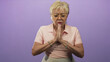 © Krakenimages.com - Woman praying with hands pressed together and eyes closed, wearing pink polo and glasses in a studio; serenity reflection.