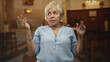 © Krakenimages.com - Woman gesturing with hands and looking to the side near pews and an altar inside a building; contemplation memory.