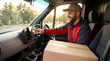 © Starmarpro - Smiling man in delivery van with package, using navigation, ready to deliver parcels