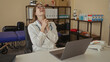 © Krakenimages.com - Woman wearing white coat with stethoscope hanging over shoulder typing on laptop with hands in clinic; concentration.
