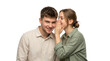 © fatima - Young couple sharing a secret woman whispering to man with a surprised expression on a white background