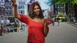 © Krakenimages.com - Hispanic teenage woman holding strawberries in hand on street market, red off shoulder blouse and headband visible; joy summer freshness.