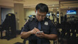 © Krakenimages.com - Chinese policeman writes notes in notepad with hand in navy uniform standing in gymnasium next to treadmill machine; duty.