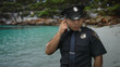© Krakenimages.com - Young chinese man in police uniform points finger to head in forest with rocky terrain visible; contemplation.