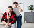 © New Africa - Happy father and son wearing stylish outfits indoors