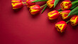 © Bediha Duru Öksüz - Red and yellow tulips on red background with copy space. Beautiful red and yellow tulips arranged on a red background with copy space. Spring, greeting cards, Valentine’s Day and celebration concepts.