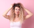 © New Africa - Unhappy woman with tangled hair on pink background