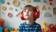 © miss irine - Child with red headphones listens to sound. Focus on auditory input for learning and sensory development. Early education for kids with developmental differences. Noise and sound exploration.