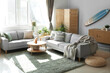 © Pixel-Shot - Interior of light living room with surfboard, houseplants and sofas