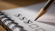© photo for everything - Close up photo of a pencil marking checkboxes on a white paper in a notebook. Focus is on the pencil tip and the last checkmark being made