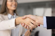 © fizkes - Close up view handshake between businessman and businesswoman. Two business partners shaking hands, as gesture of formal agreement, mutual trust, or beginning of successful professional collaboration