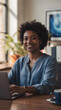 © Maryen - Smiling young woman working on a laptop at a desk in an office environment