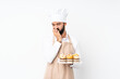 © luismolinero - Young man holding muffin cake over isolated white background having doubts