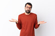 © luismolinero - Caucasian handsome man with beard over isolated white background having doubts while raising hands